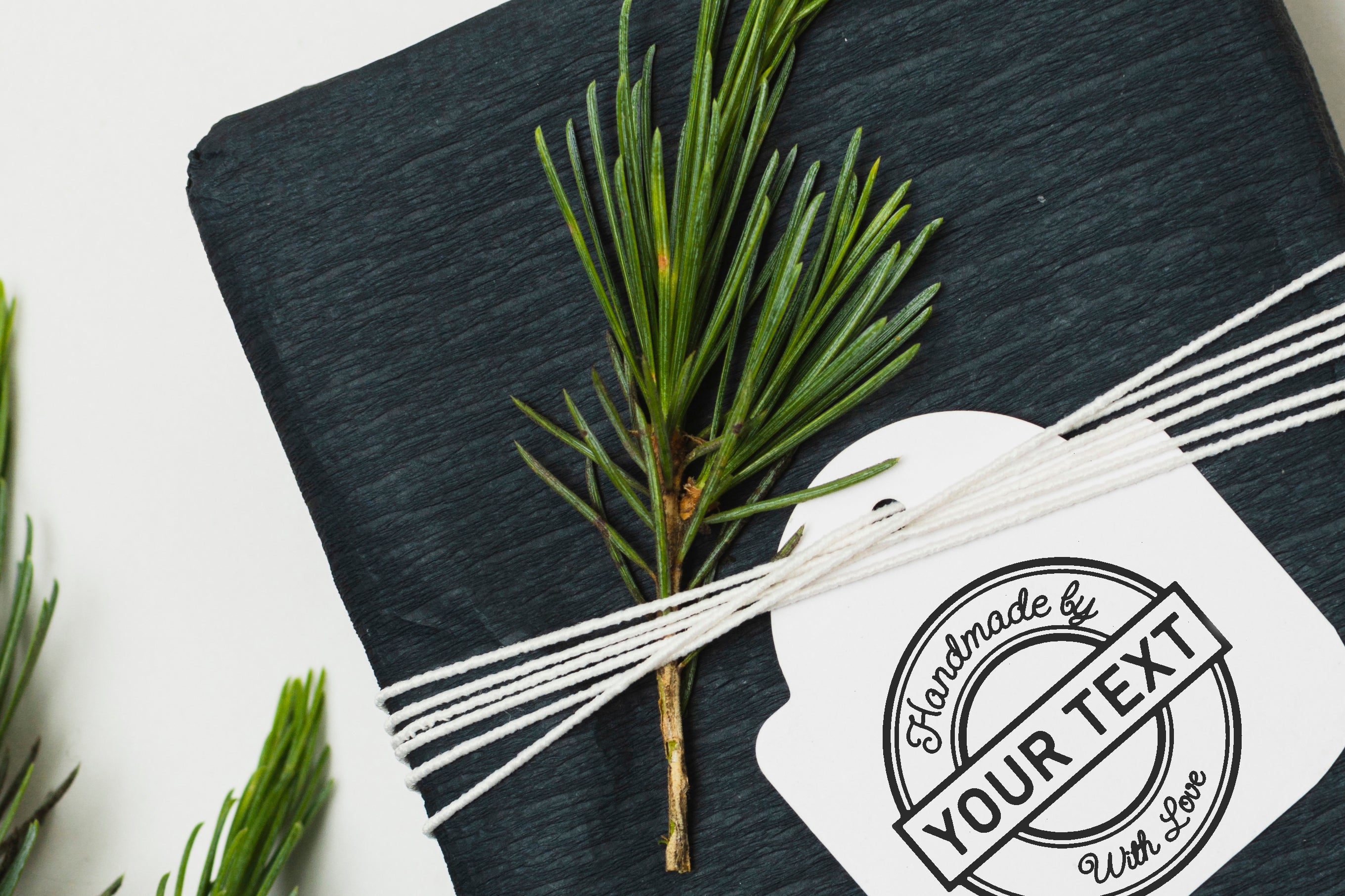 Gift wrapped package with handmade tag and pine sprig decoration, perfect for special occasions.