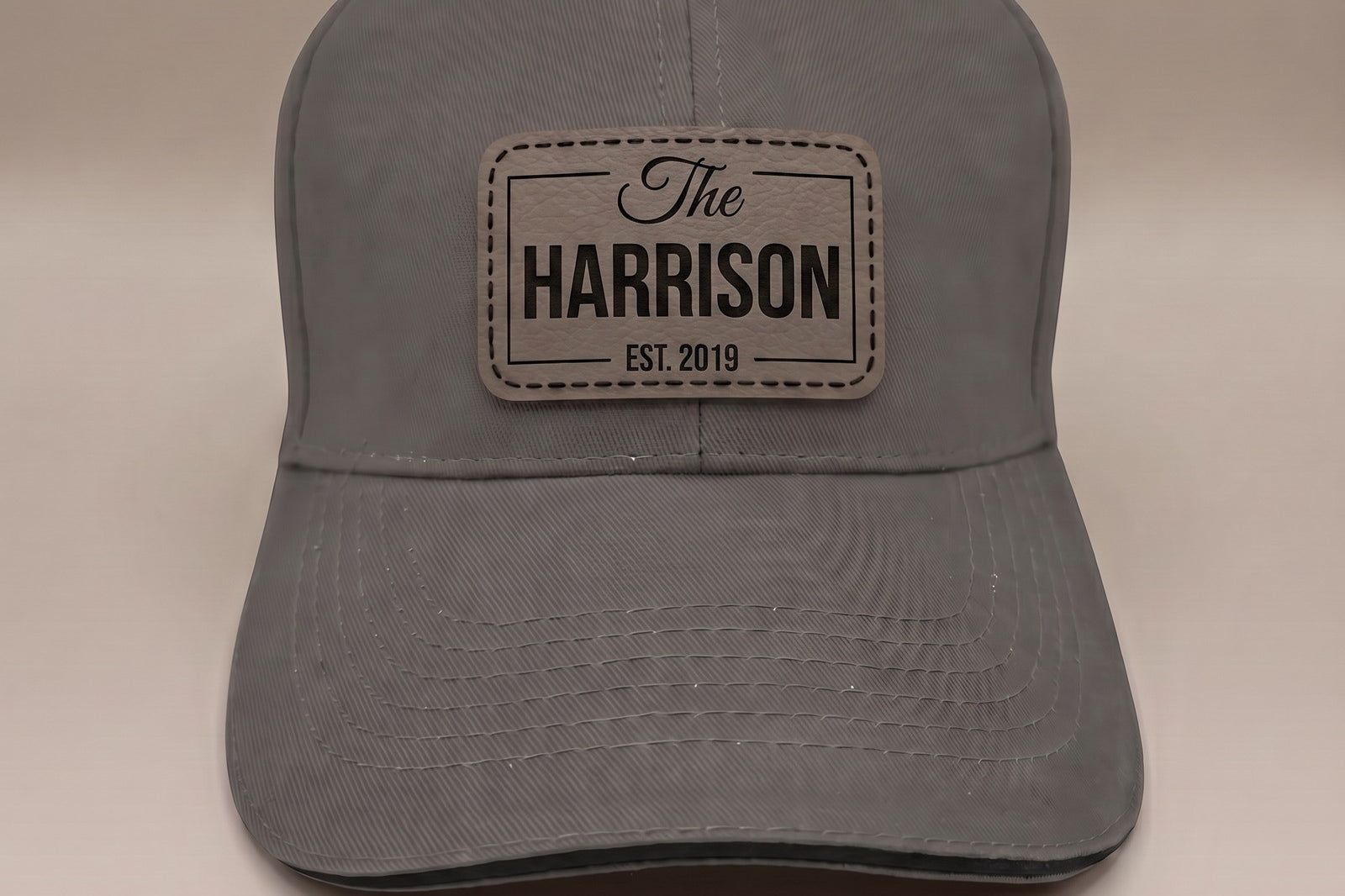 Graphite grey custom leather patch cap with engraved family name badge, The Harrison Est. 2019
