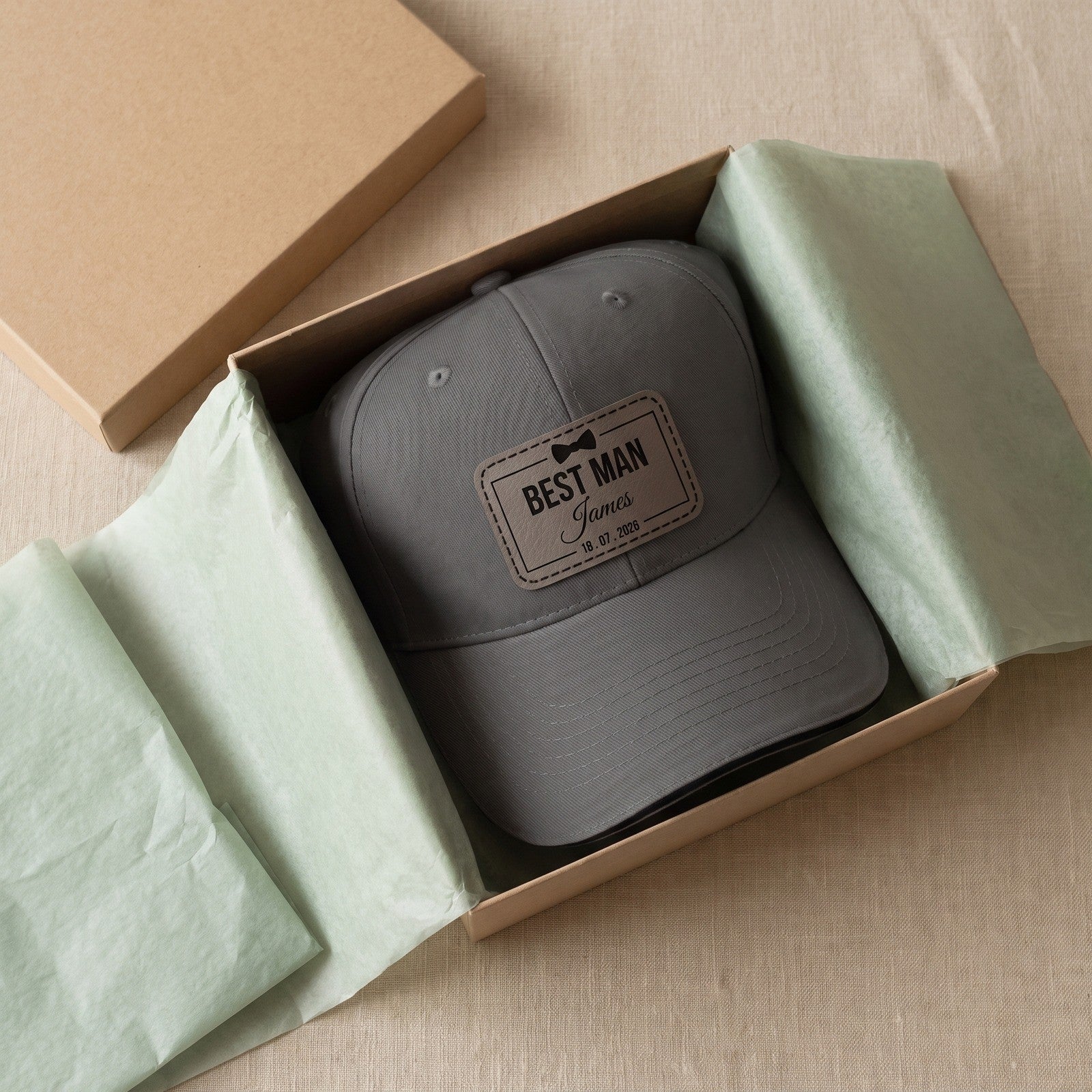 Personalised leather patch cap in a kraft gift box with green tissue paper