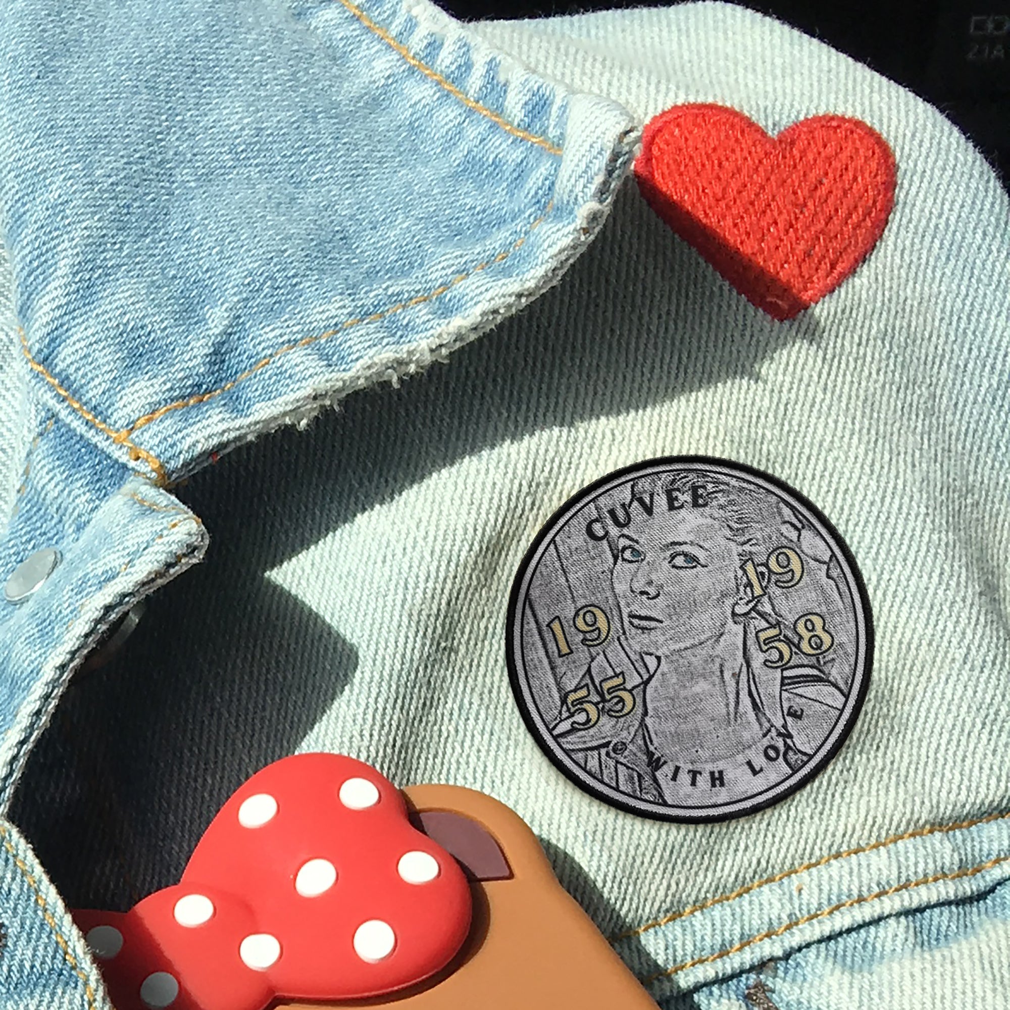 Custom embroidered patch on denim jacket with heart detail, showcasing vibrant colors and unique design.