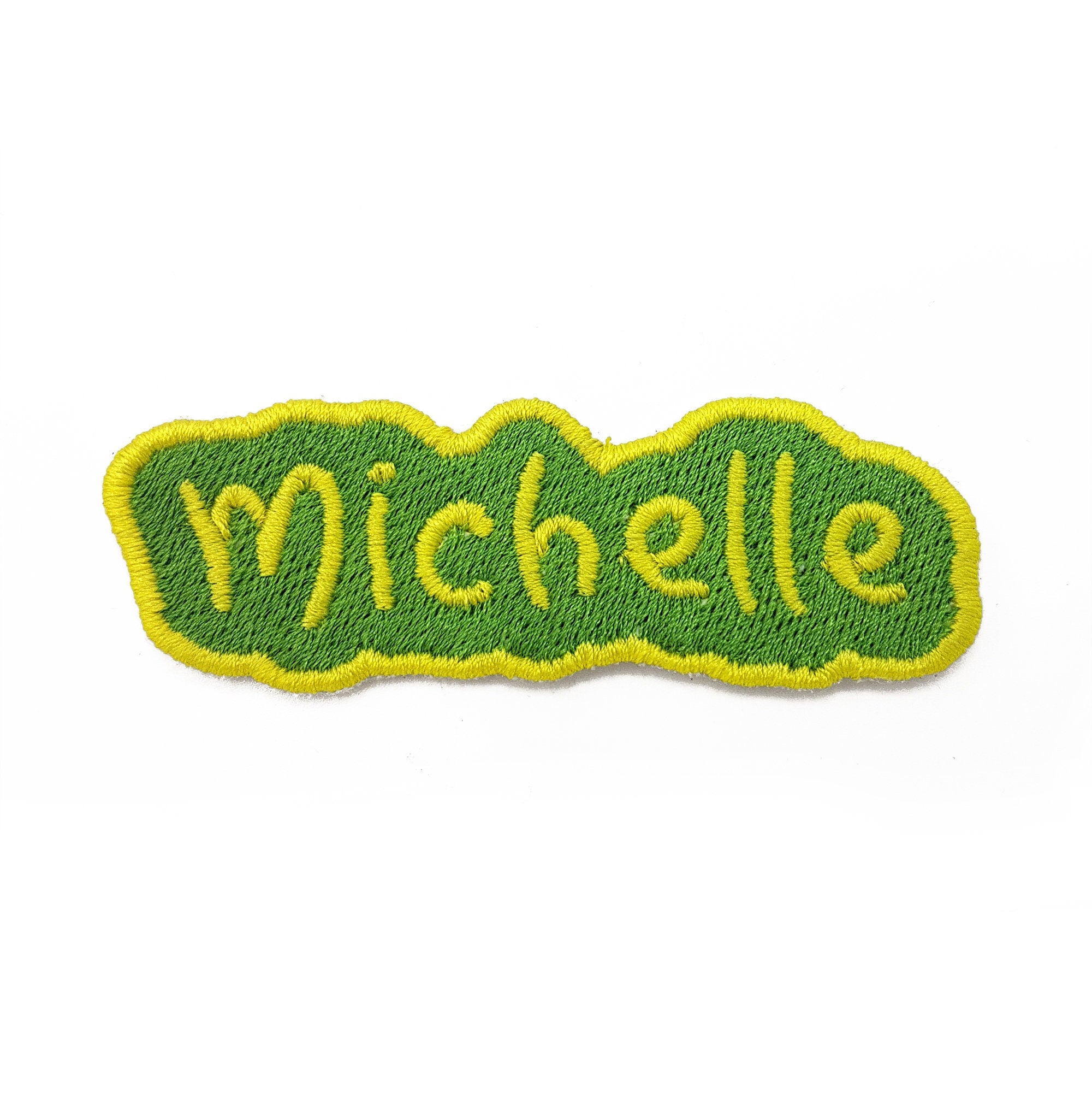 Personalised embroidered name patch in vibrant green and yellow that reads 'Michelle', perfect for bags and clothing.
