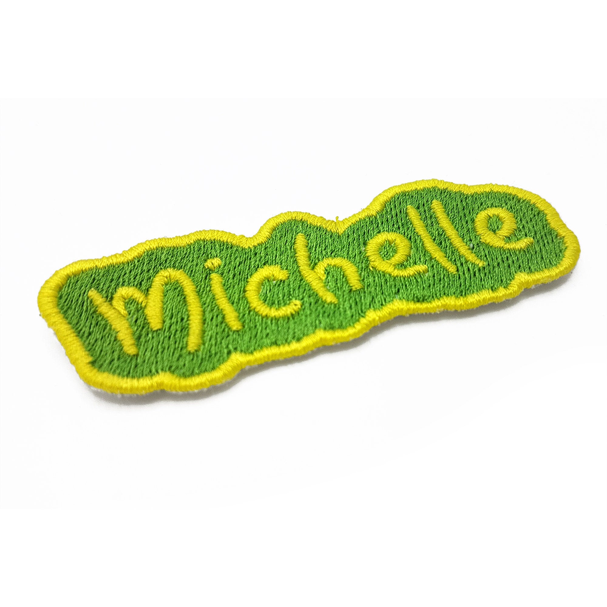 Personalized embroidered name patch in green with the name Michelle, perfect for bags and clothing.