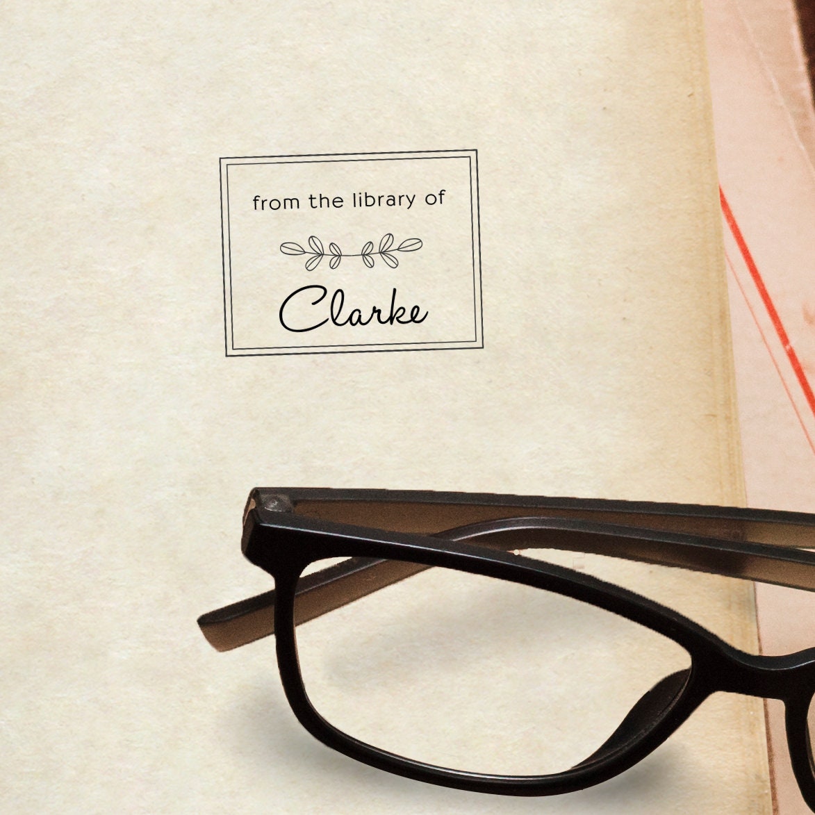 Custom book stamp design with the text 'from the library of Clarke' next to black reading glasses.