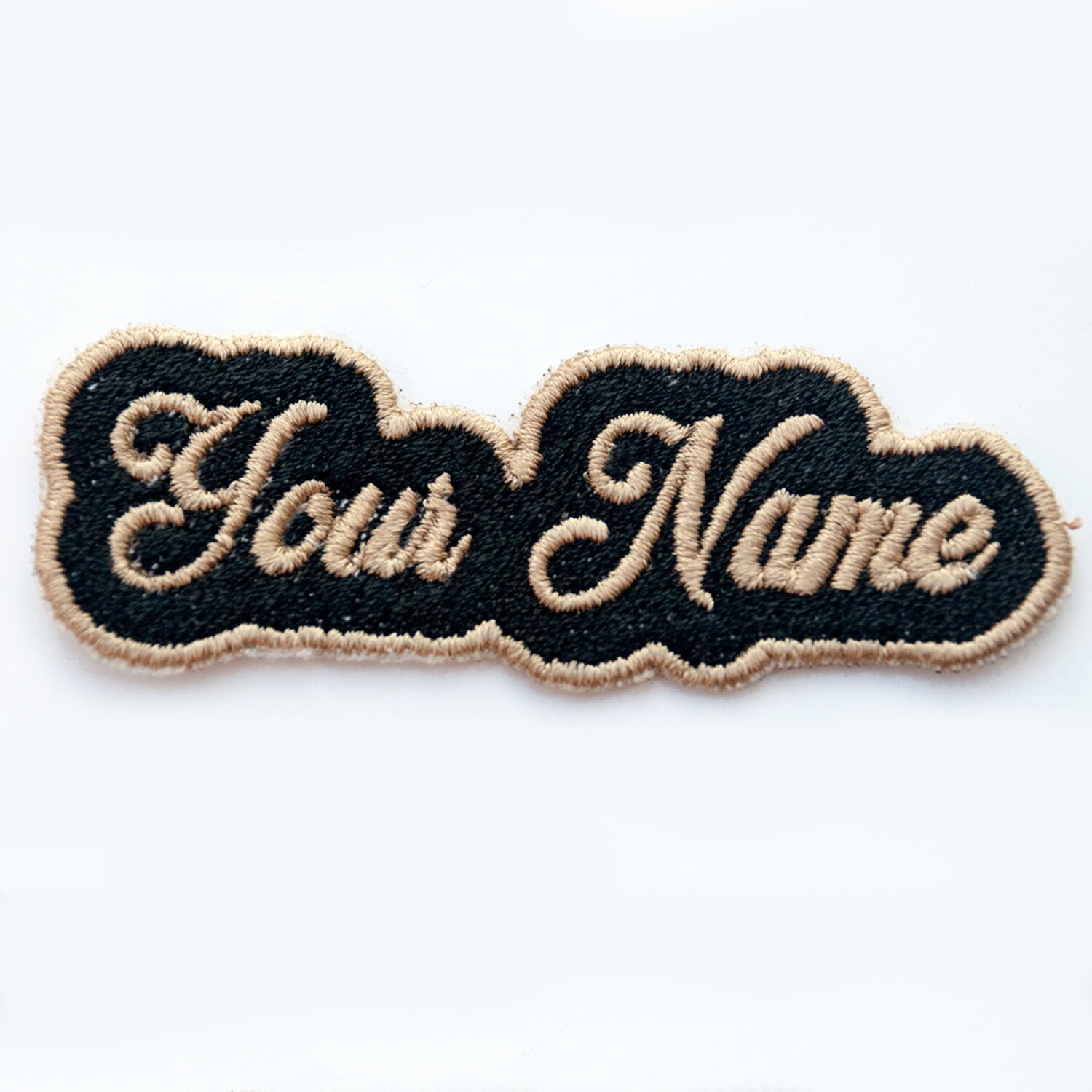 Personalized embroidered patch with black background and beige text, customizable for bags, jackets, and more.