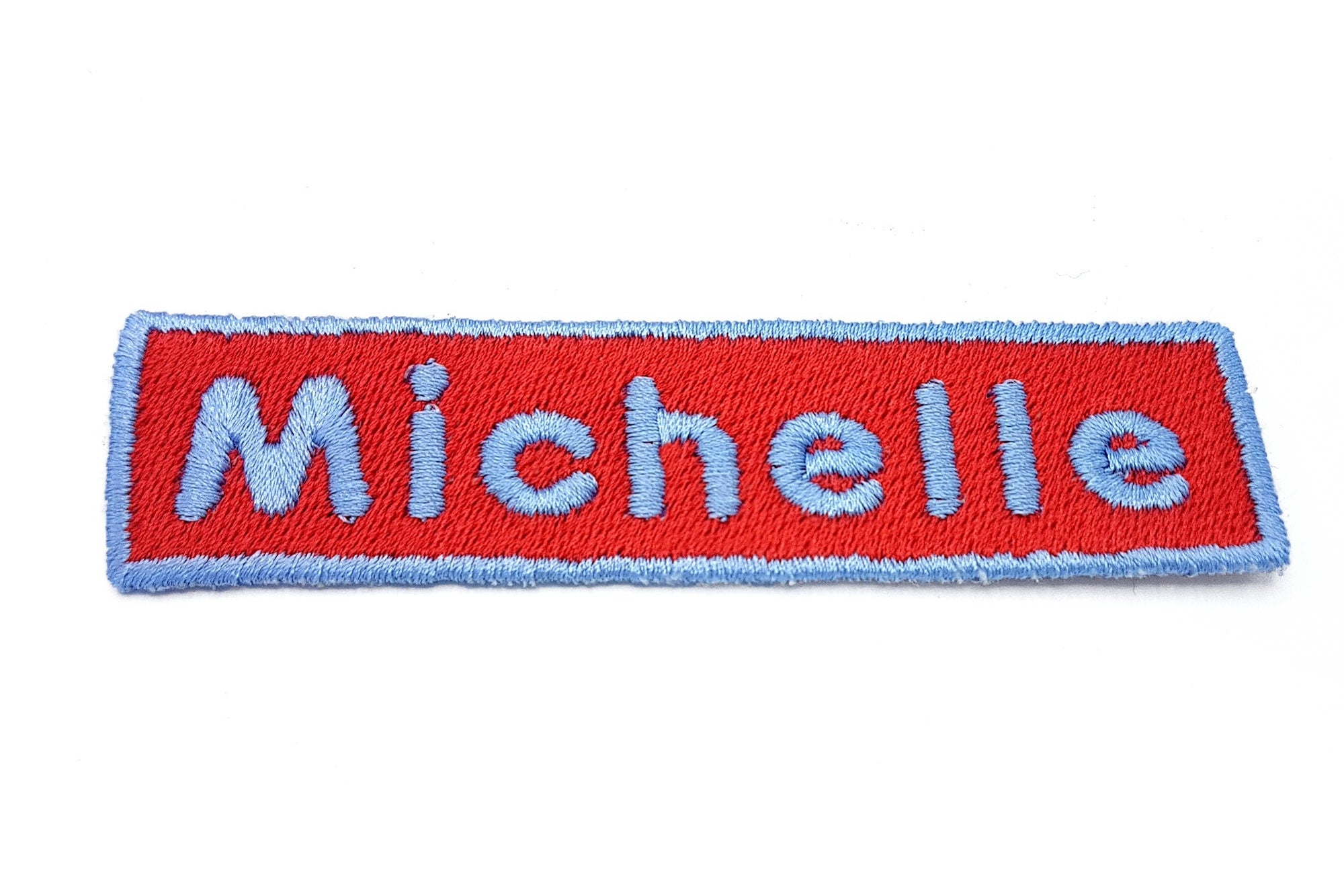 Personalized embroidered name patch for 'Michelle' in vibrant red and blue colors, ideal for bags and jackets.