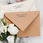 Custom address stamp on envelopes with white roses, showcasing traditional and elegant design for wedding invitations.