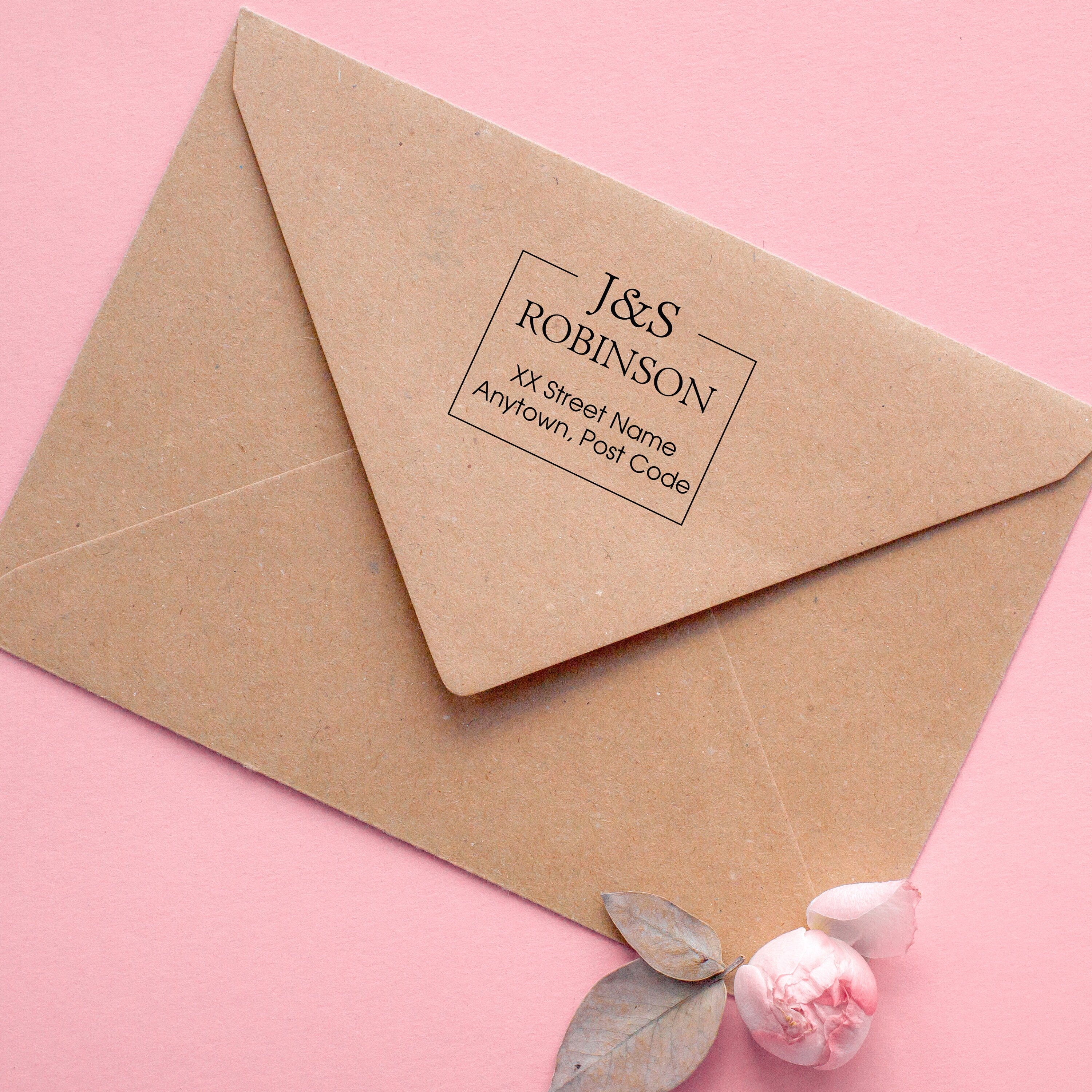 Custom return address stamp on a kraft envelope with floral accents.