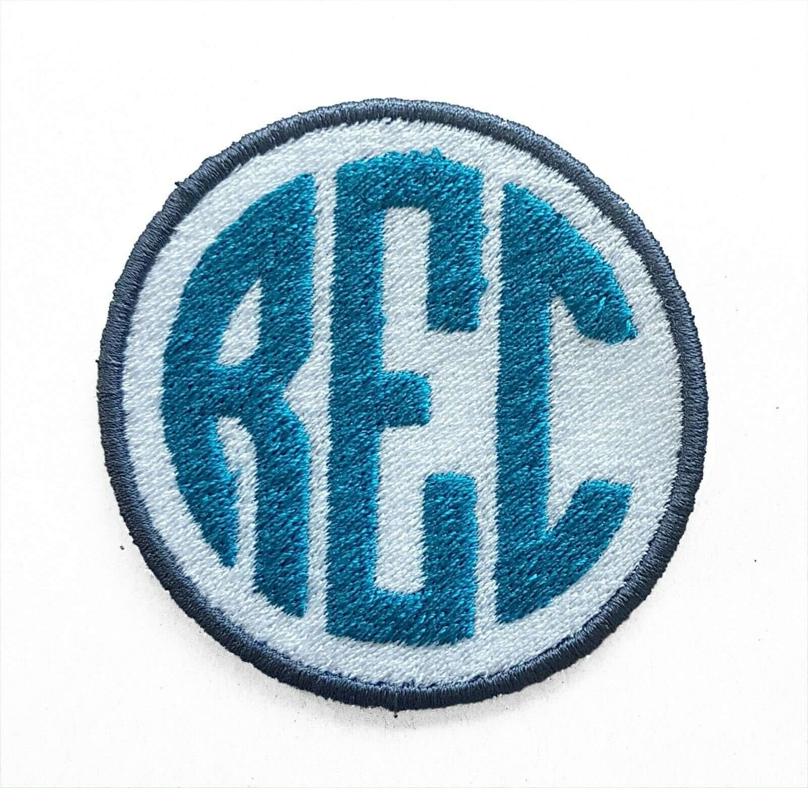 Custom embroidered monogram patch with teal letters in circle design, perfect for personalizing bags and jackets.