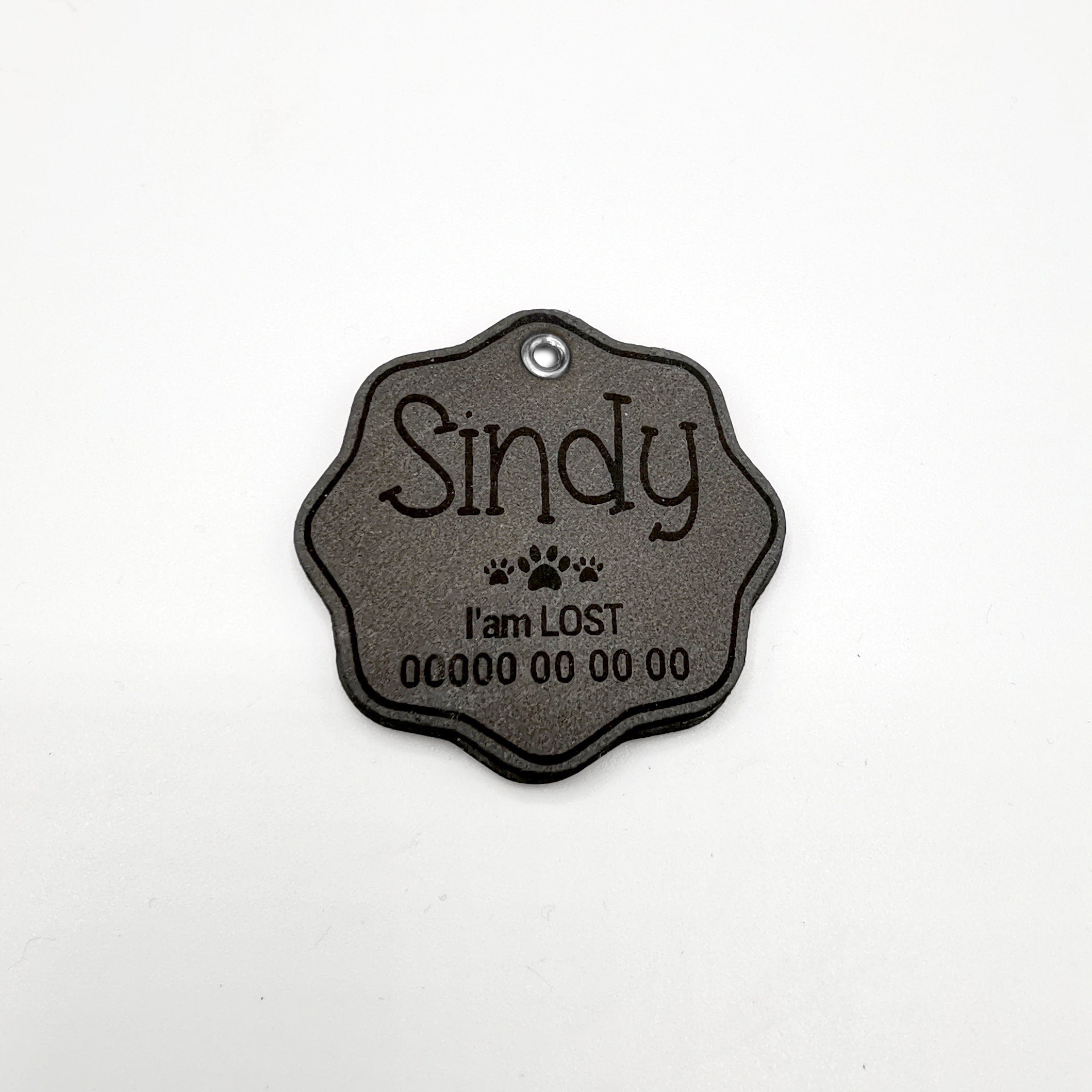 Custom engraved leather dog name tag with the name 'Sindy' and 'I'm LOST' message for pet identification.