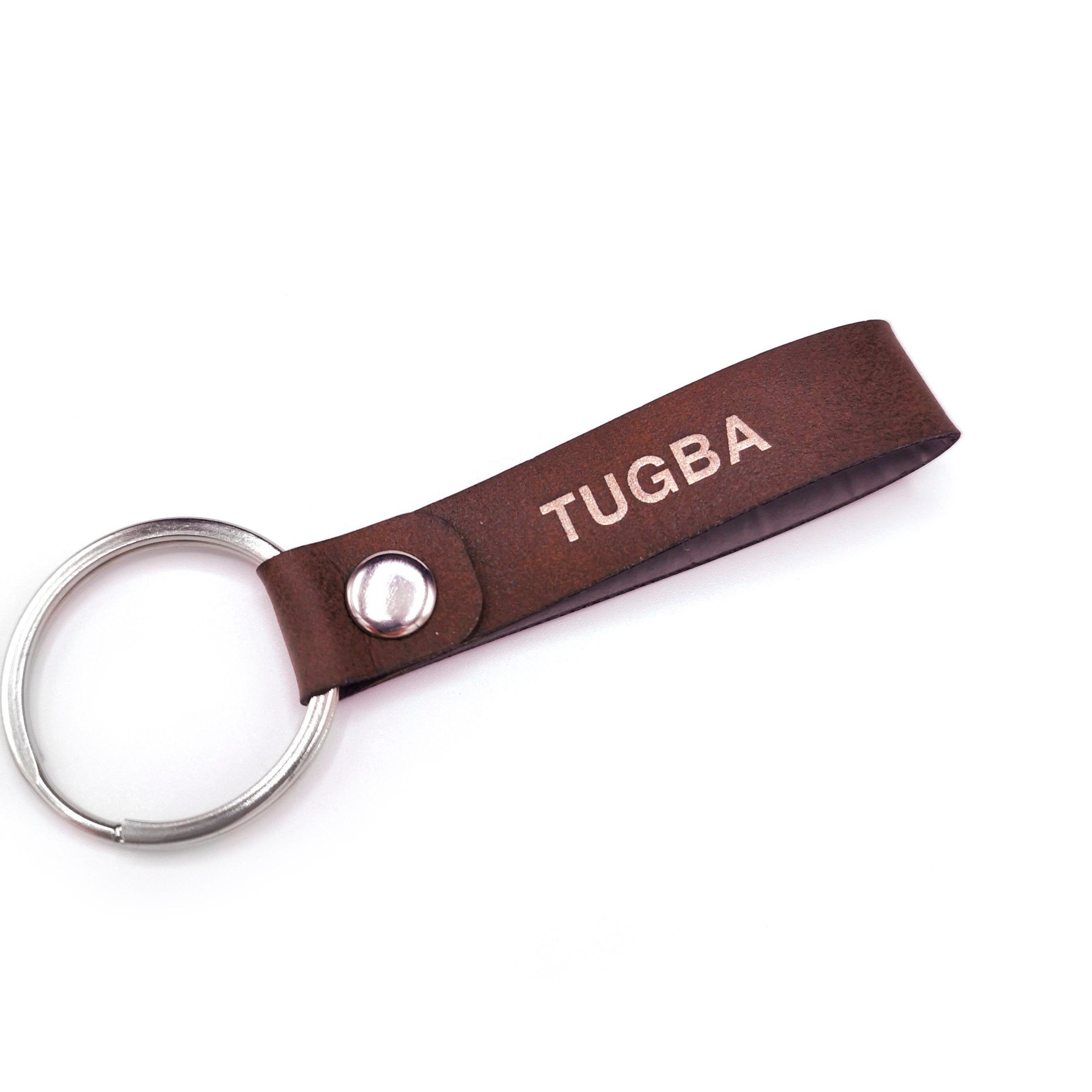 Custom leather keyring with personalized engraving, featuring the name 'TUGBA' on a brown PU leather strap.