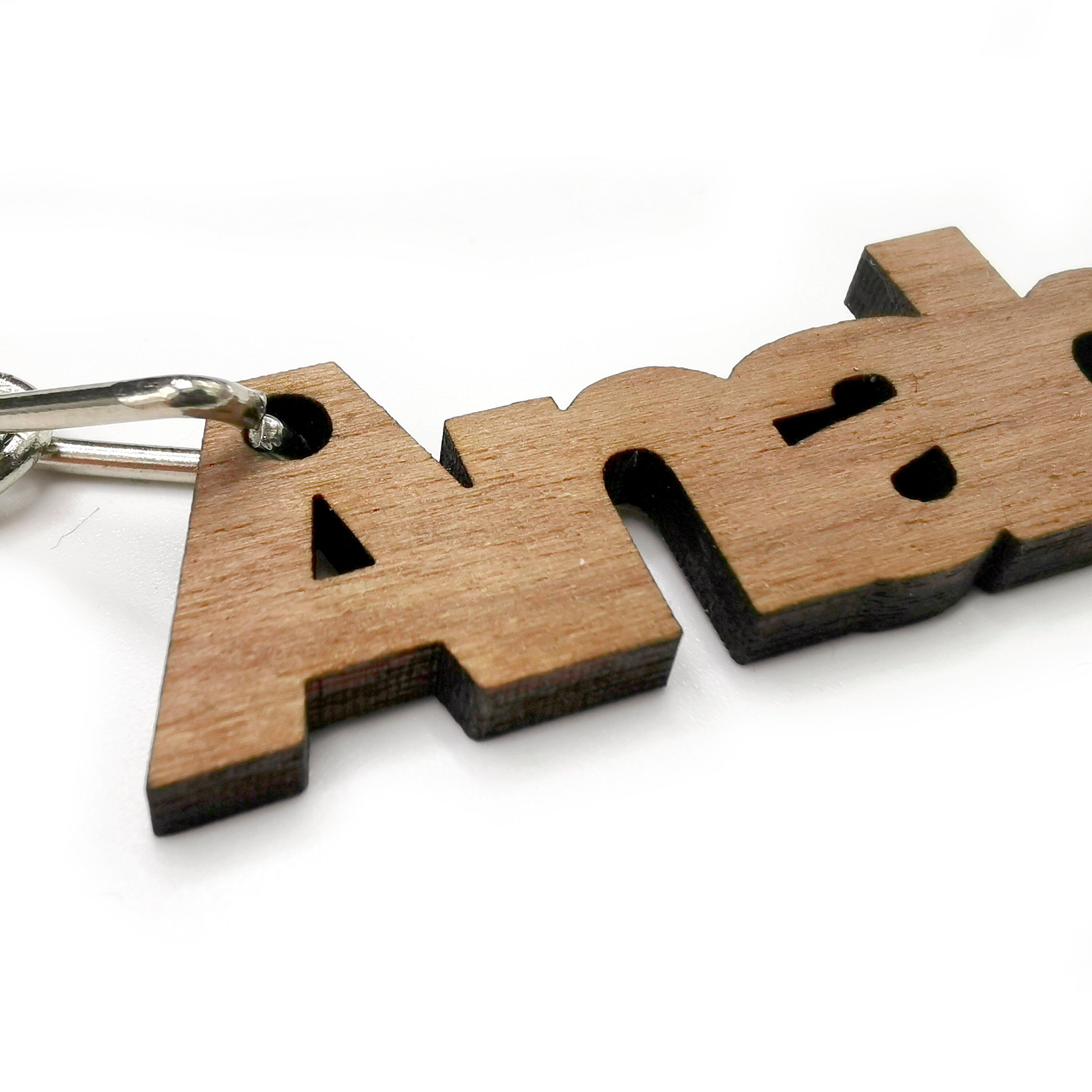 Custom solid walnut wooden keyring with laser engraved text for personalized gifts.