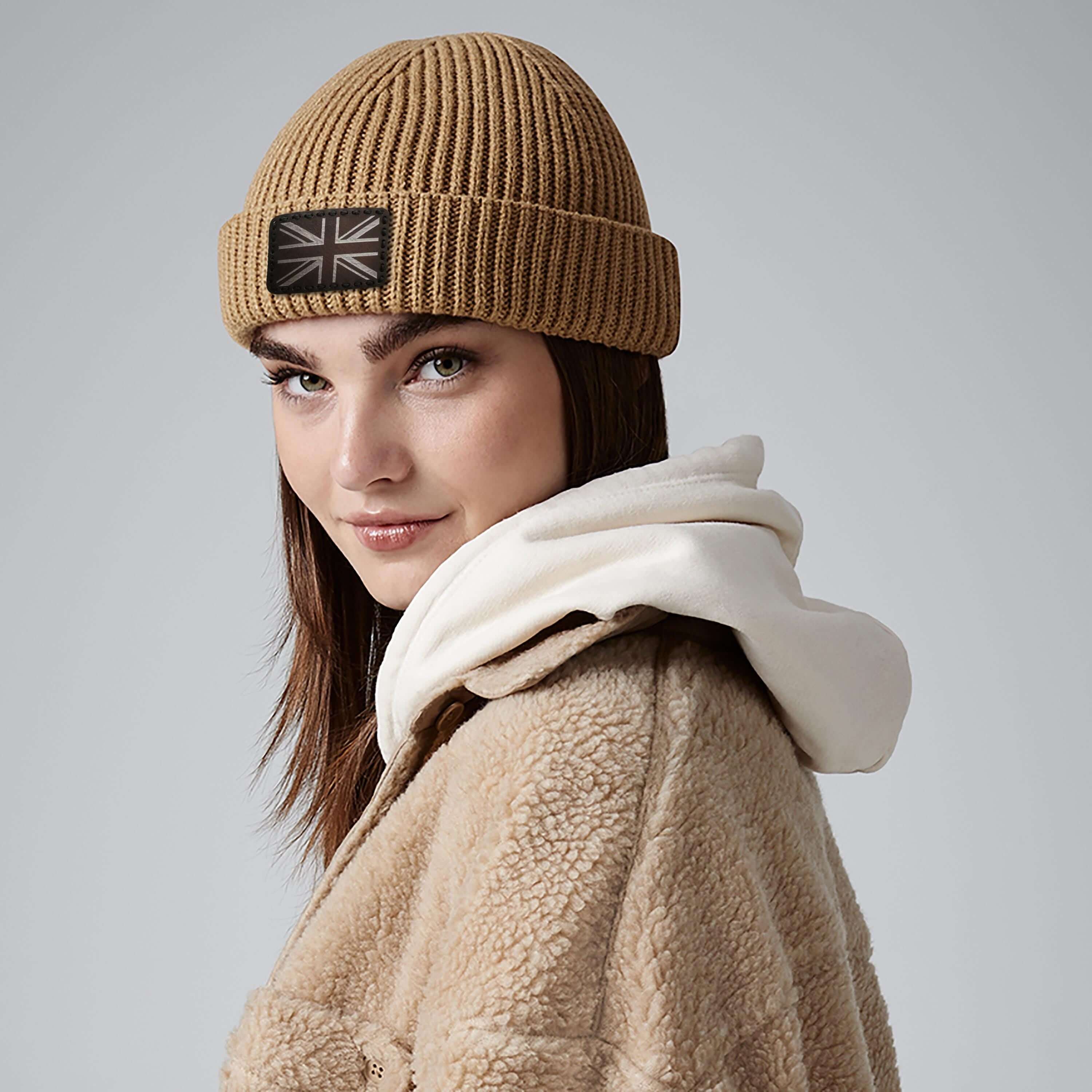 Fashionable woman wearing a custom beanie with leather patch, cozy winter style, perfect for men and women.
