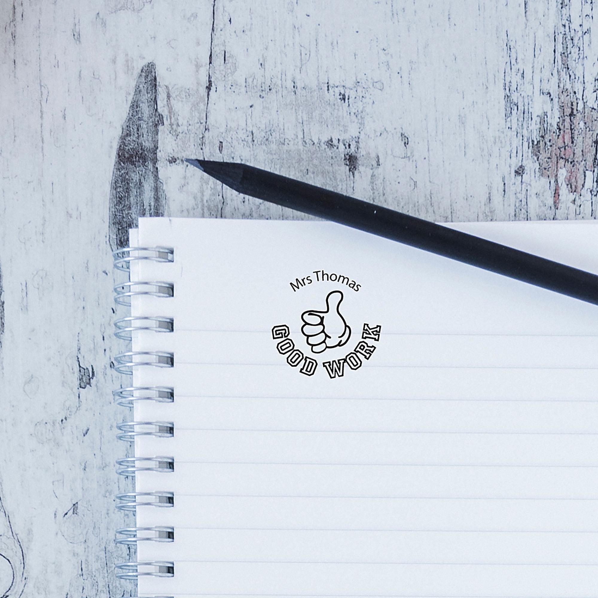 Custom teacher stamp on notebook page, promoting positive feedback for students' work.