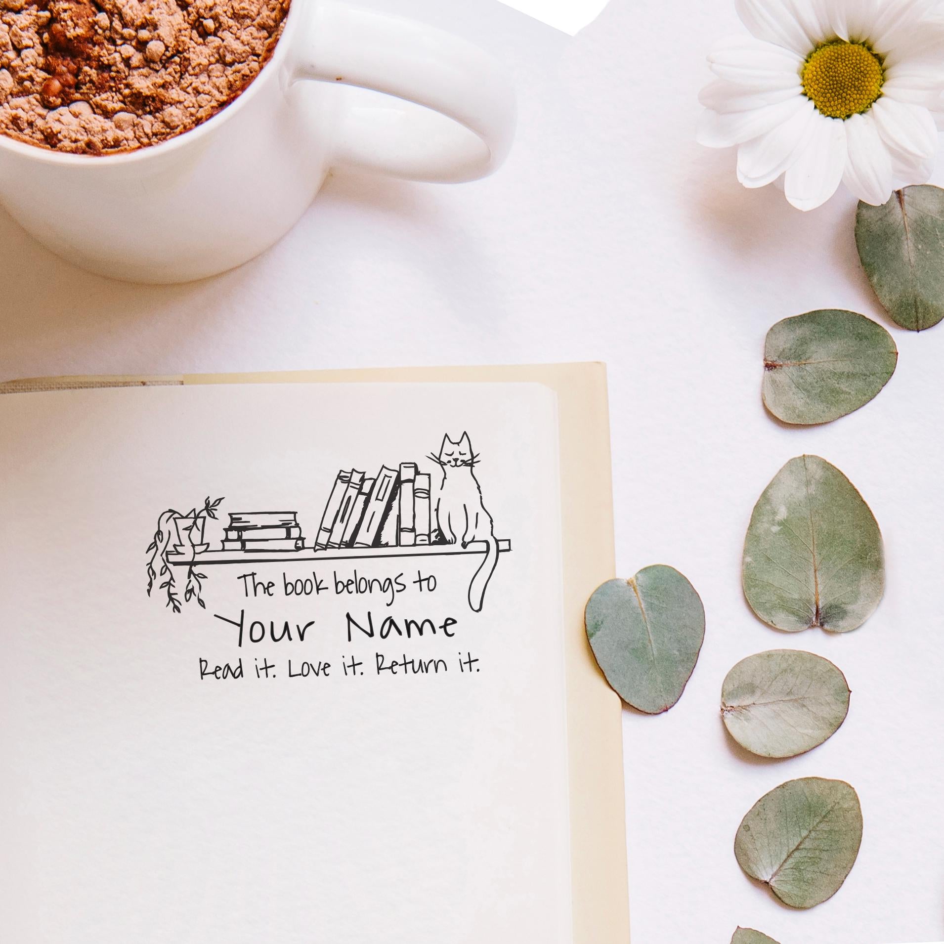 Personalized library stamp design on a book page with a cat, emphasizing ownership and love for reading.