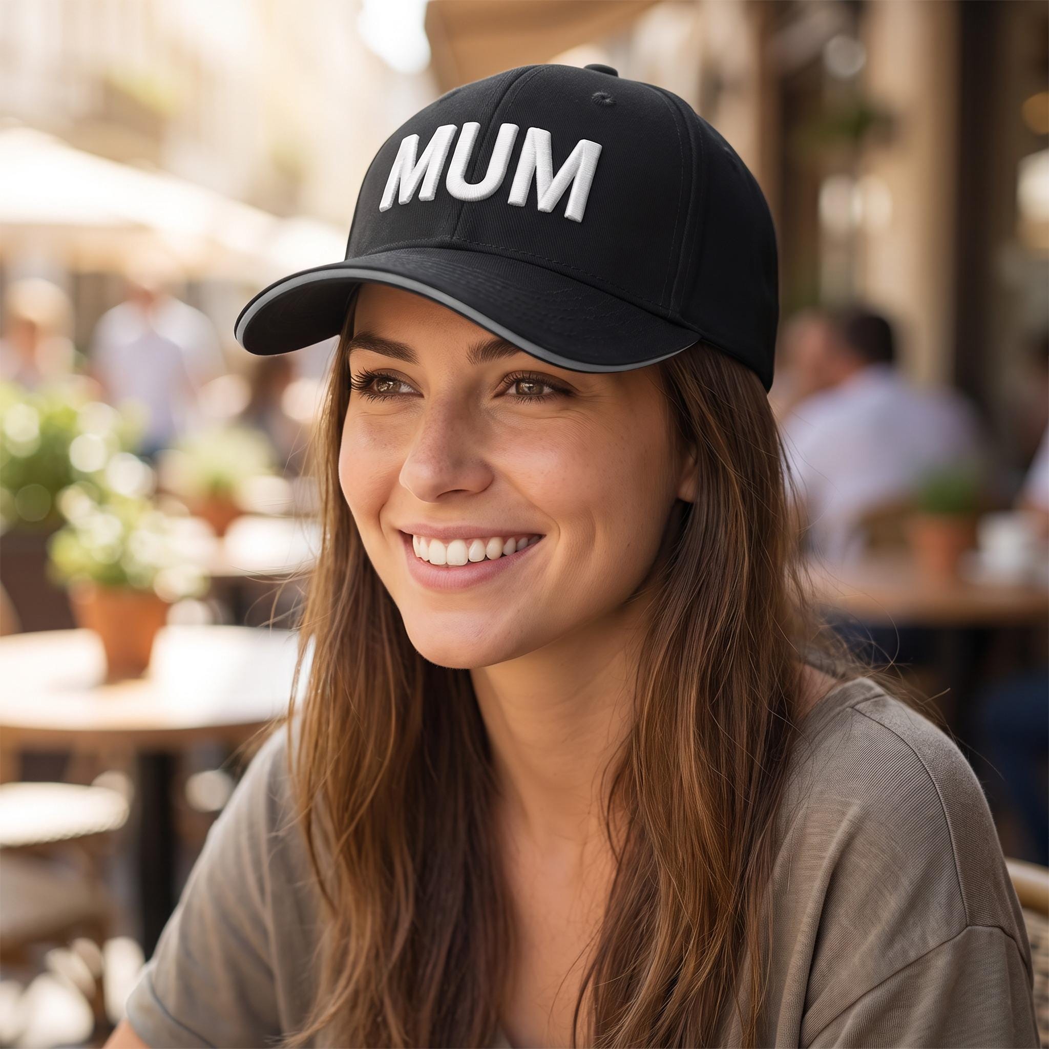 Woman wearing a black custom cap with MUM in white 3D puff embroidery and a grey peak trim