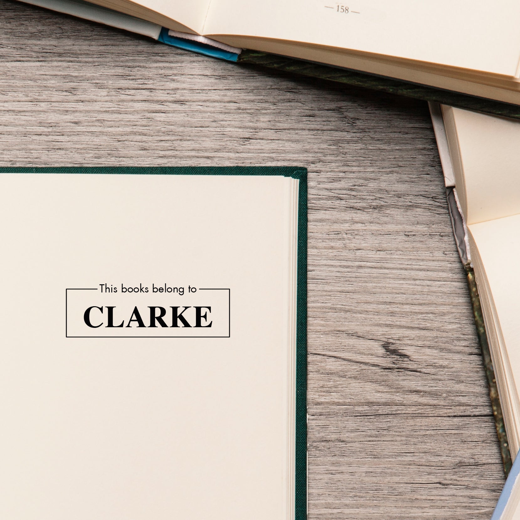 This Book Belongs To personalized stamp on an open book, perfect for book lovers and classrooms.