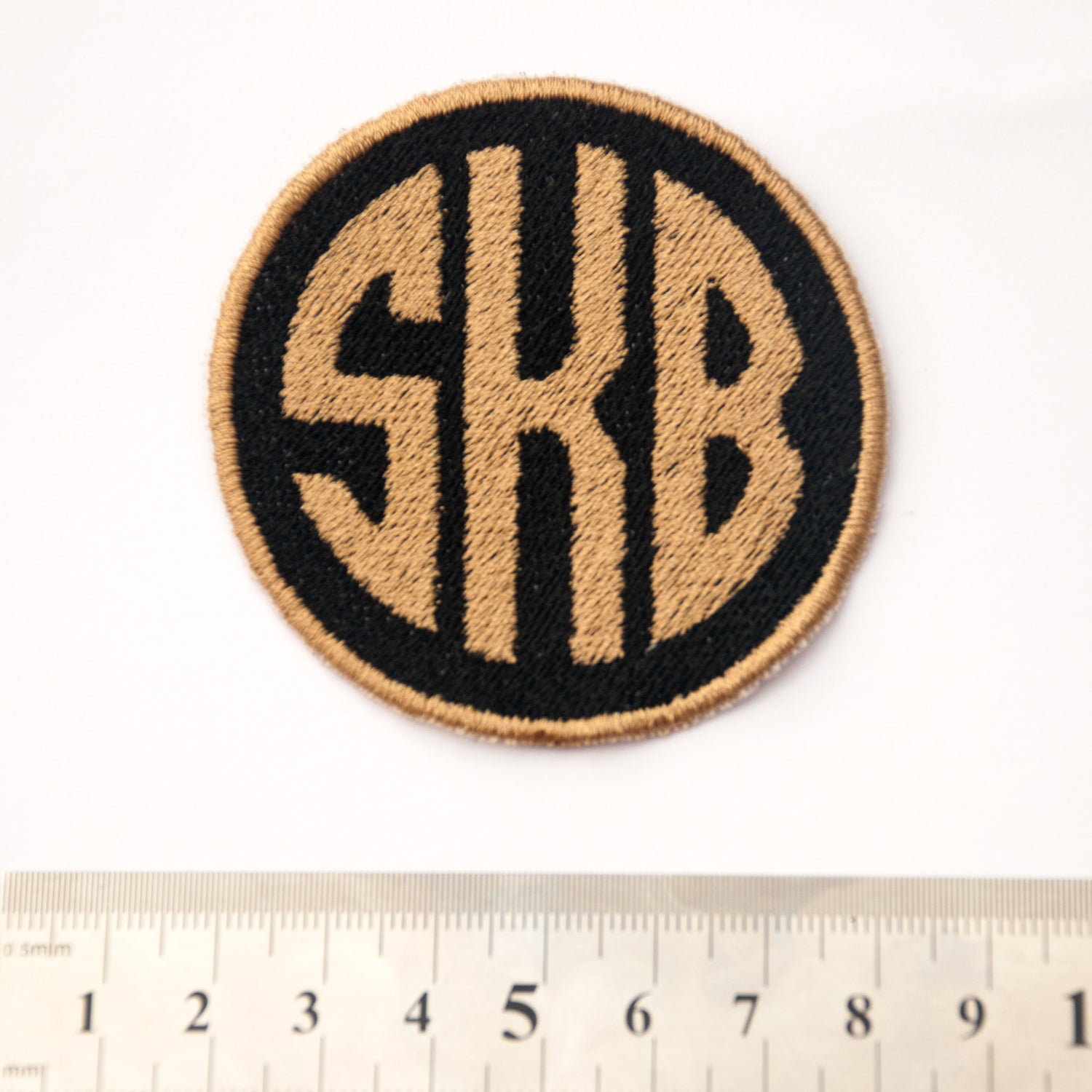 Personalised embroidered circle monogram patch with initials SKB, 6cm size, available in multiple thread colors.