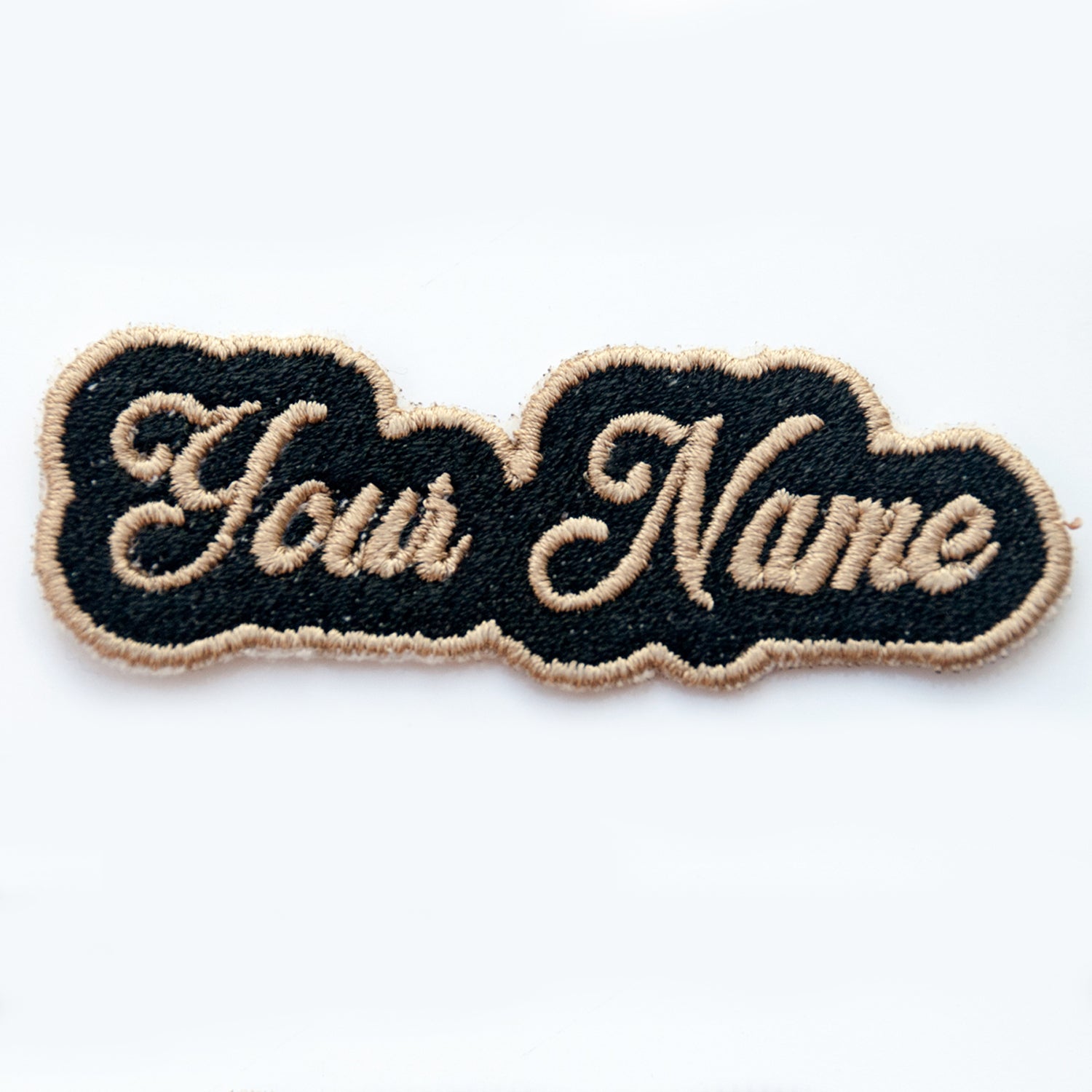 Personalized embroidered patch with custom name in cursive lettering on a black background.