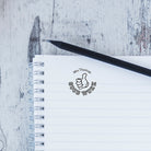 Custom teacher stamp with 'Mrs Thomas' and 'GOOD WORK' on a notebook, perfect for classroom use and teacher gifts.