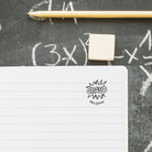 Custom teacher stamp on notebook with pencil, personalized with 'BRAVO' and 'Mrs. Jones' for classroom use.