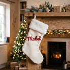 3D embroidered name patch reading Mabel ironed onto a cream Christmas stocking by the fireplace