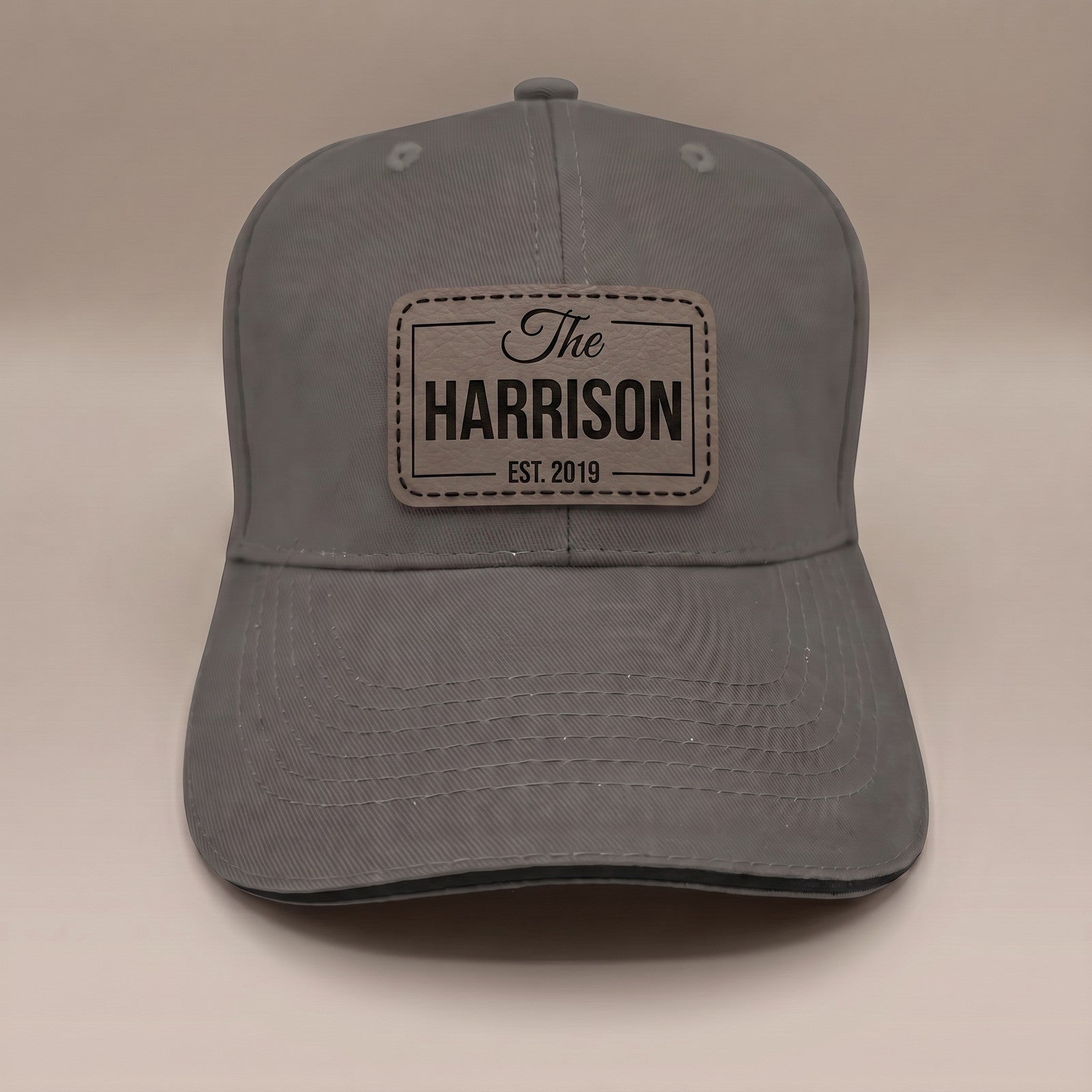 Graphite grey custom leather patch cap with engraved family name badge, The Harrison Est. 2019