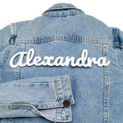 White 3D name patch reading Alexandra on the back of a denim jacket
