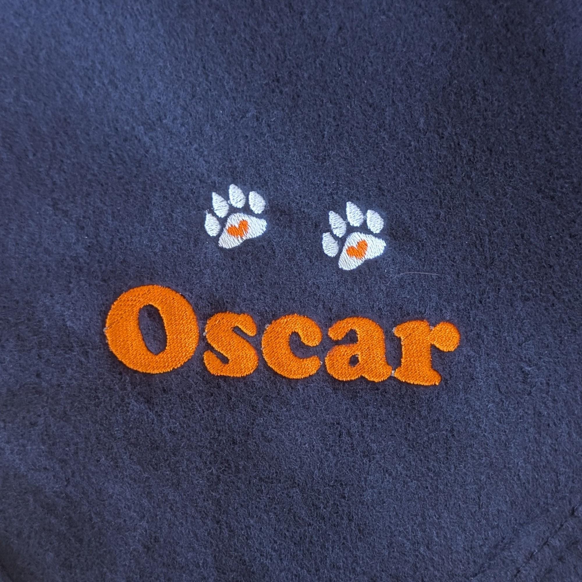 Close up of real embroidery name and heart paw prints on navy fleece