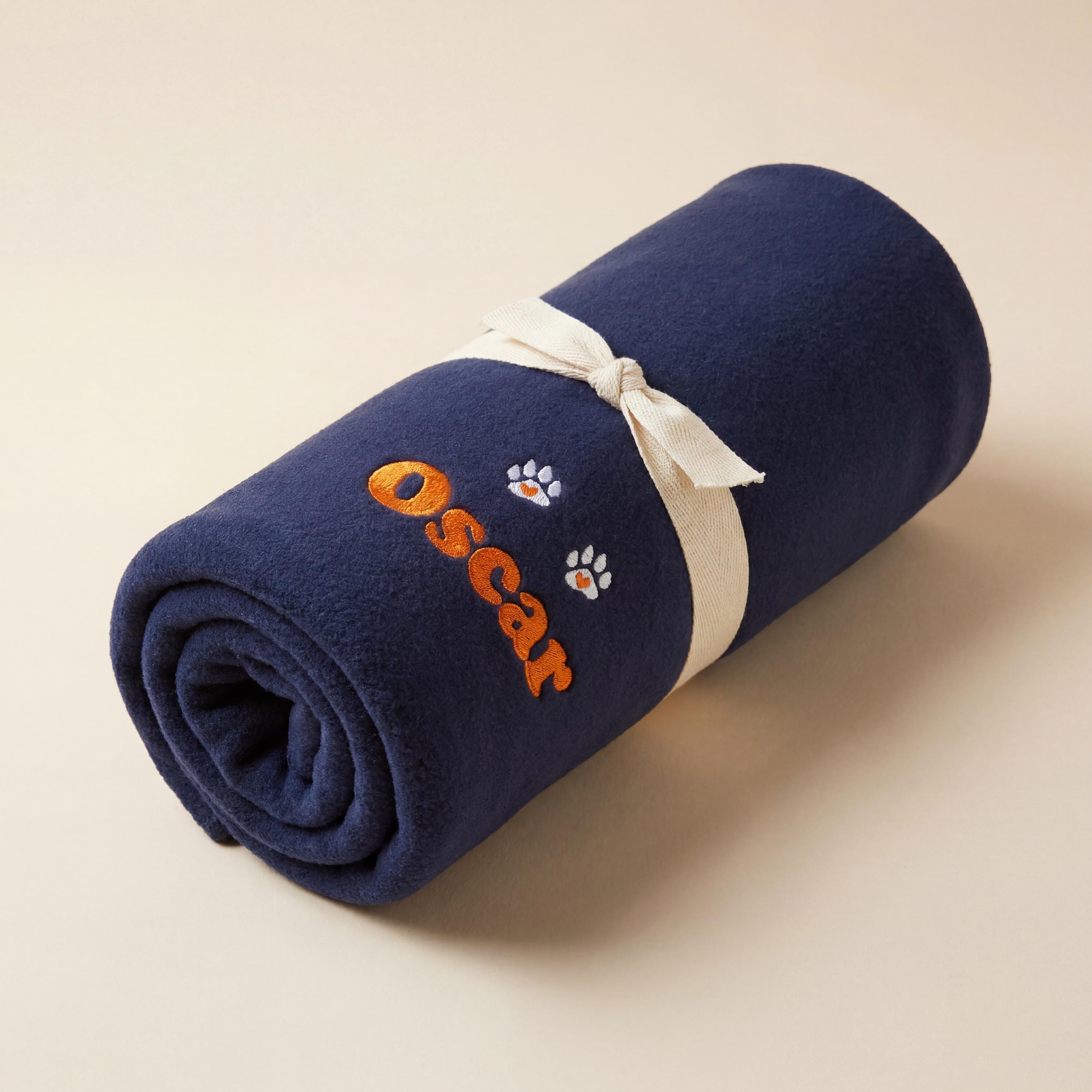 Rolled personalised dog blanket tied with cotton band as a gift