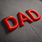 Close-up of the raised red 3D puff embroidery lettering on a grey baseball cap