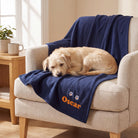 Dog sleeping on personalised navy fleece blanket on cream armchair