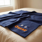 Personalised dog blanket spread on bed with embroidered corner