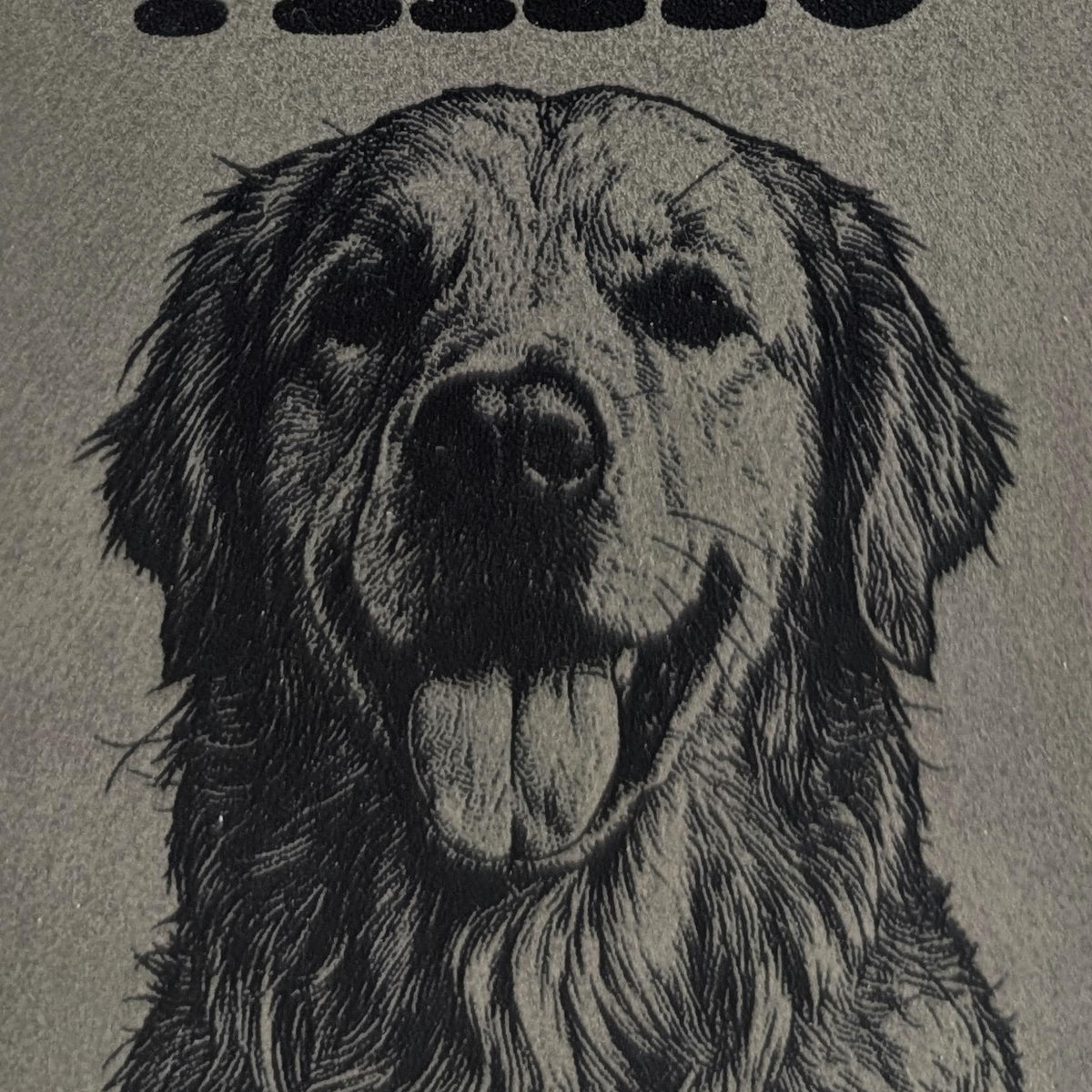 Close-up of a golden retriever engraved into grey vegan leather, showing the fur texture