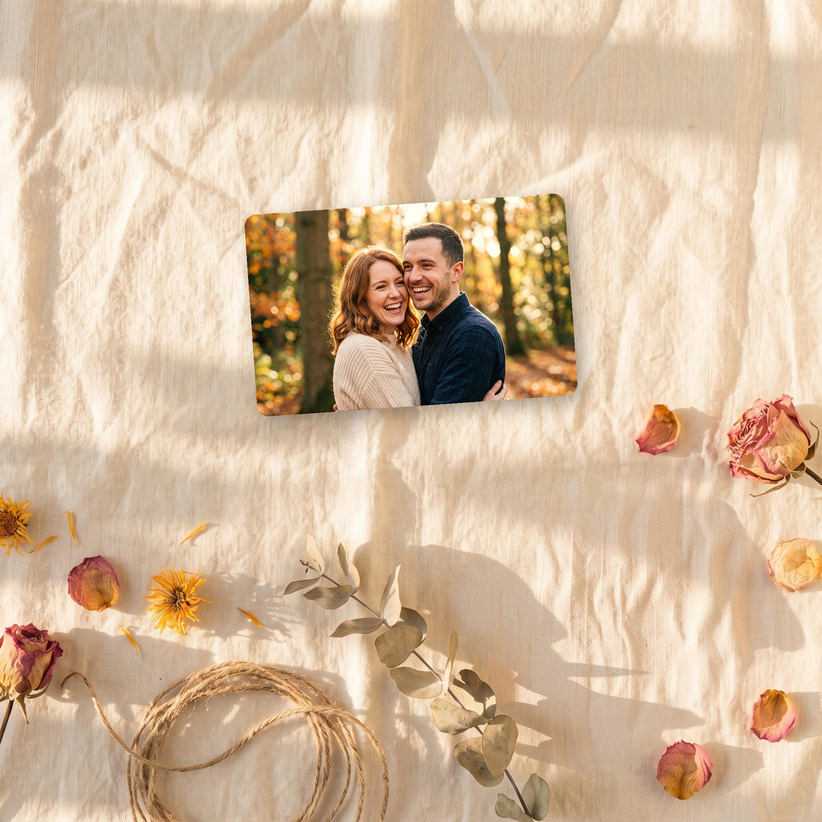 Photo wallet card on cream linen with dried flowers and twine
